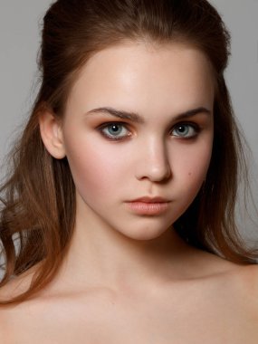 Muhteşem genç esmer kadın portresi. Mükemmel kaşlı, temiz makyajlı güzel bir kız. Parti için seksi bayan makyajı. Gri arkaplanda izole