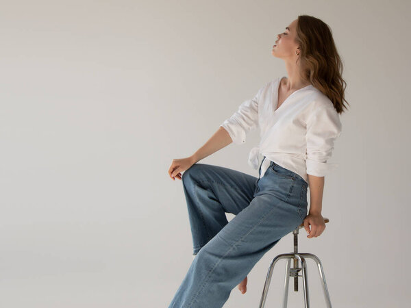 Красивая женщина-модель. Красавица. Образец тестового портрета с молодой красивой моделью, позирующей на сером фоне. Естественный макияж и волнистая прическа