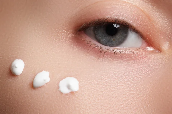 Portrait of young woman with fresh clean face with points of moisturizing  cream under the eye — Stock fotografie