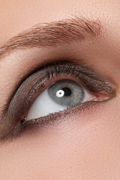 Blaues weibliches Auge mit geschwungenem Smoky Make-up und langen Wimpern — Stockfoto