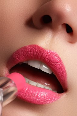 Kadın Pembe dudakları boyalı. Güzellik dudak makyaj. Mükemmel cilt, dolgun dudaklar. Retro makyaj. Profesyonel makyaj sanatçısı seksi dudak makyaj uygulamak. Moda makyaj