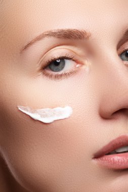 Temiz Cilt yakın çekim güzel genç kadın. Güzel kadın yüz studio beyaz üzerine kapatın. Genç kadın kozmetik krem temiz taze bir yüz. Cilt bakım kavramı