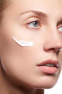 Temiz Cilt yakın çekim güzel genç kadın. Güzel kadın yüz studio beyaz üzerine kapatın. Genç kadın kozmetik krem temiz taze bir yüz. Cilt bakım kavramı