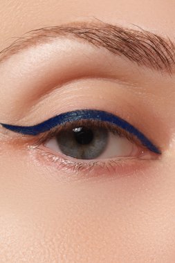 Beauty make-up for blue eyes. Perfect skin, long eyelashes. Classic blue arrows makeup. Retro make up. Eyeliner makeup