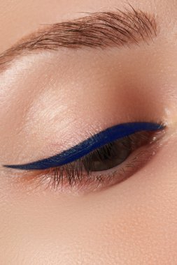 Beauty make-up for blue eyes. Perfect skin, long eyelashes. Classic blue arrows makeup. Retro make up. Eyeliner makeup