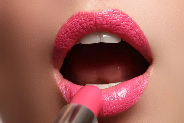 Женщина красила розовые губы. Косметика для губ. Идеальная кожа, полные губы. Ретро макияж. Профессиональный визажист наносит сексуальный макияж губ. Мода макияж — стоковое фото