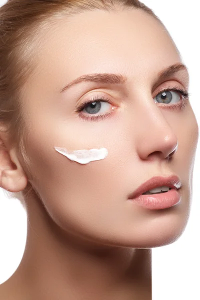 Vacker ung kvinna med ren frisk hud närbild. Vacker kvinna ansikte nära upp studio på vitt. Ung kvinna med kosmetiska grädde på en ren nytt ansikte. Skin care koncept — Stockfoto