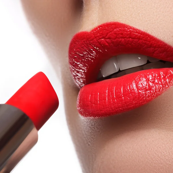 Extremo acercamiento al modelo aplicando lápiz labial rojo. Maquillaje. Maquillaje retro de moda profesional. Lápiz labial rojo . — Foto de Stock