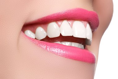 Macro happy woman's smile with healthy white teeth, bright pink .lips make-up. Stomatology and beauty care. Woman smiling with great teeth on white background. Cheerful female smile with fresh clear skin