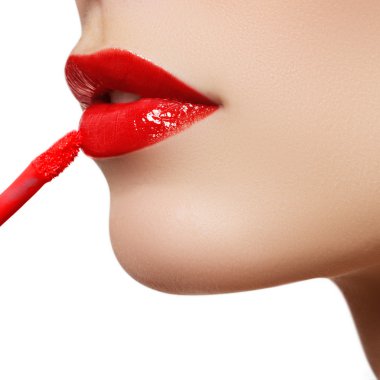 Professional lips make-up. Lipgloss and brush. Lipstick. Beauty girl applying lip gloss. Sexy lips. Beauty red lip makeup detail. Beautiful make-up closeup. Sensual open mouth. Lipstick and Lipgloss. Kiss.