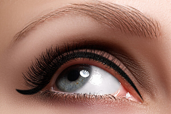 Macro shot of woman's beautiful eye with extremely long eyelashes. Sexy view, sensual look. Female eye with long eyelashes