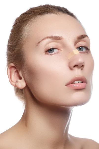 Woman cleaning her face. Beautiful young woman with clear-up patches or plaster on her nose looking at camera. Skin care concept. Beauty and healthcare. — Stockfoto