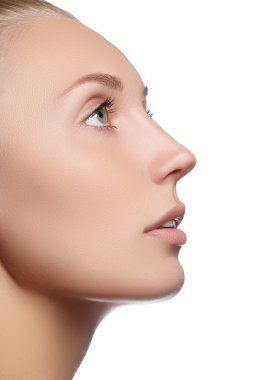 Beautiful face of young woman with clean fresh skin. Portrait of beautiful young woman with beautiful blue eyes and face - on white background. Close-up portrait of beautiful woman's purity face with natural make-up. Cute model with clean shiny skin