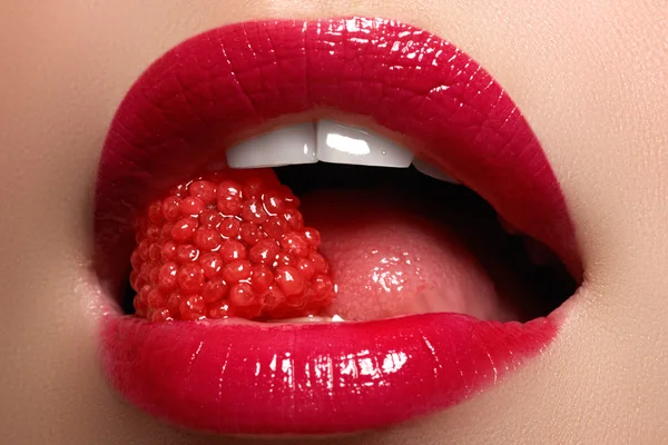 Kadının dudakları parlak moda kırmızı parlak makyaj ile Close-up. Makro kanlı lipgloss makyaj. Kırmızı seksi dudaklar. Açık ağız. Manikür ve makyaj. Kavram olun.
