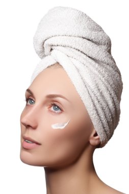 Güzel, sağlıklı bir kadının güzel portresi. Stüdyo, beyaz bir arka planda çekici bir kızı vurdu. Yüzünde bir fırçaya neden oldu. Yüzü soyulmuş. Kafasında havluyla güzel bir kız