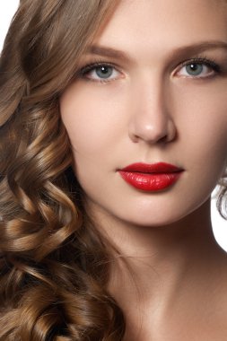 Beautiful young woman with long curly hair. Beautiful  model with long curly brown hair. Lovely model with shiny volume curly hair. Pin-up style. White background