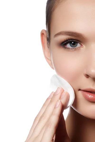 Happy european woman with cotton pad, isolated on white background. Beauty fresh girl cleaning face with cotton swab. Beautiful young woman cleaning her face with cotton — Stockfoto