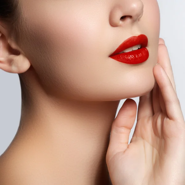 Close-up shot of woman lips with glossy red lipstick. Glamour red lips make-up, purity skin. Retro beauty style. Beautiful model girl with beauty makeup, red lips, perfect fresh skin. Youth and Skin Care Concept — Stock fotografie