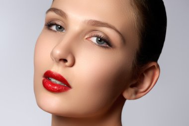 Portrait of elegant woman with red lips. Beautiful young model with red lips. Sexy woman model with bright red lips makeup, and healthy shiny skin. Evening glamour style, fashion make-up