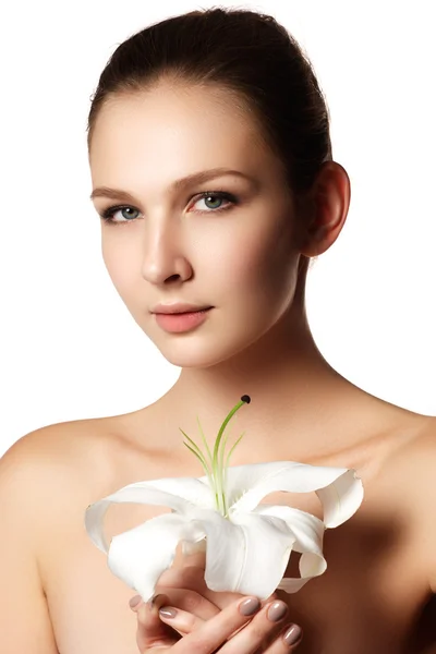 Faccia carina di bella giovane donna con giglio su mani - sfondo bianco. Volto di bellezza di giovane donna con fiore. concetto di trattamento di bellezza — Foto Stock