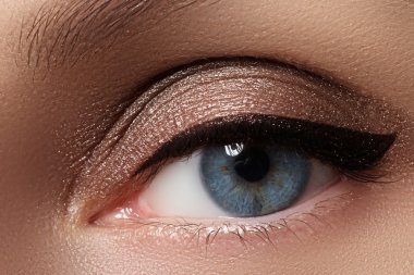 Kozmetik ve makyaj. Seksi siyah liner makyaj güzel kadın gözle. Moda büyük ok şekli kadının göz kapağı üzerinde. Şık akşam makyaj