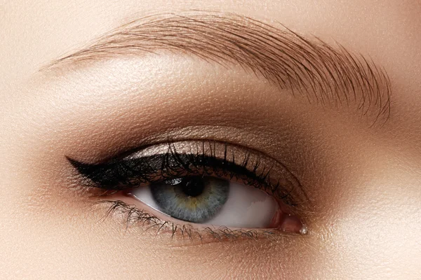 Kosmetik & Make-up. schöne weibliche Auge mit sexy schwarzen Liner Make-up. Mode große Pfeilform auf dem Augenlid der Frau. schickes Abend-Make-up — Stockfoto