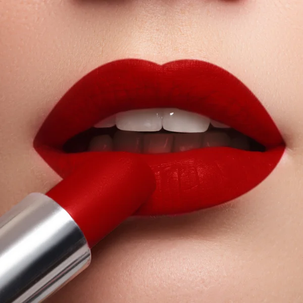 Extremo acercamiento al modelo aplicando lápiz labial rojo oscuro. Maquillaje. Maquillaje retro de moda profesional. lápiz labial rojo oscuro. Labios de vino — Foto de Stock