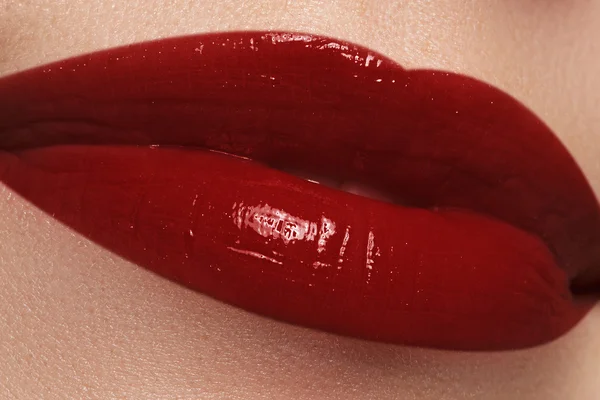 Primer plano de los labios de la mujer con maquillaje de lápiz labial rojo oscuro de moda. Maquillaje de brillo de labios macro sexy horizontal. Cosméticos y maquillaje. Maquillaje de labios húmedos sexy. Dulce beso. Primer plano de hermosos labios llenos — Foto de Stock