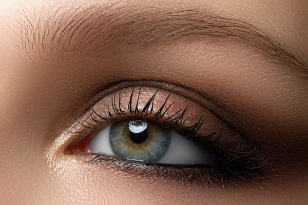 Elegância close-up de olho feminino com clássico marrom escuro maquilhagem fumegante. Macro tiro da parte da cara da mulher. Beleza, cosméticos e maquiagem . — Fotografia de Stock