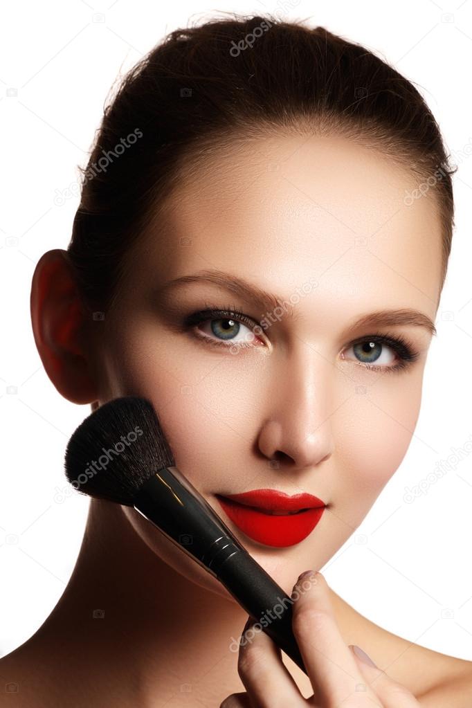 Beauty Girl with Makeup Brushes. Natural Make-up for Brunette Woman with blue Eyes. Beautiful Face. Makeover. Perfect Skin. Applying Makeup