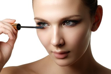 Maskara portre, uzun uygulama lashes. Rimel fırçası. Kirpik uzantıları. Mavi gözler için makyaj. Göz yapmak kadar geçerlidir. Genç güzel kadın maskara makyaj gözleri üzerine fırça ile uygulamak.