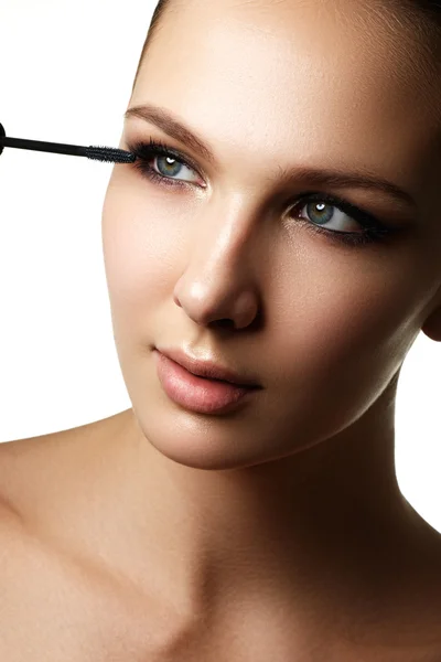 Mascara applicare primo piano, ciglia lunghe. Spazzola Mascara. Estensioni ciglia. Trucco per gli occhi blu. Trucco per gli occhi applicare. Giovane bella donna che applica il trucco mascara sugli occhi a pennello — Foto Stock