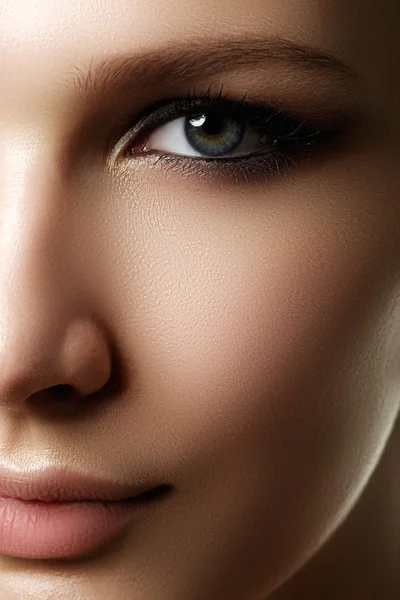 Vacker kvinna med ljusa make up ögat med sexig liner makeup. Fashion stora Pilform på kvinnans ögonlocket. Chic kvällen make-up, friska fac — Stockfoto
