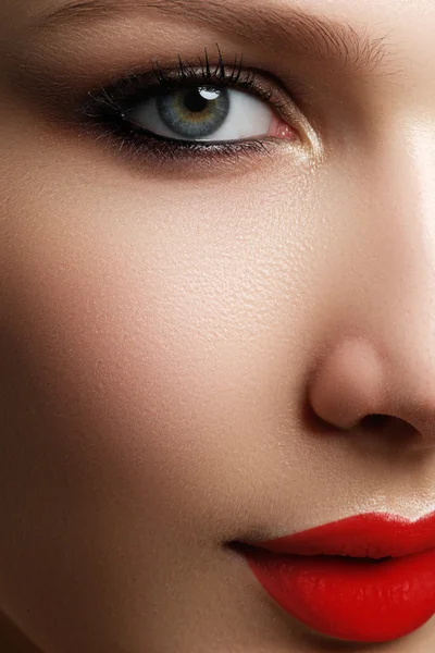 Лицо модели с голубыми глазами и идеальным макияжем. Портрет красивой молодой девушки с красными губами. Женское лицо с прозрачной кожей крупным планом. Обезжиренная. Яркая косметика — стоковое фото