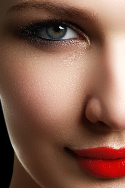 Vacker modell kvinna ansikte med blå ögon och perfekt make-up. Porträtt av skönhet ung flicka med röda läppar. Kvinnliga ansikte med klar hud närbild. Hudvård. Ljusa makeup — Stockfoto