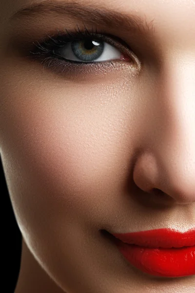 Belle femme modèle visage avec des yeux bleus et un maquillage parfait. Portrait de beauté jeune fille aux lèvres rouges. Visage féminin avec peau claire gros plan. Soins de la peau. Maquillage lumineux — Photo