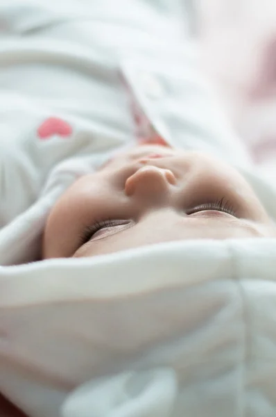 Spící děťátko v bílé kapuce — Stock fotografie