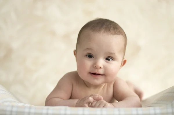 Bebê deitado de barriga para baixo e sorriso — Fotografia de Stock