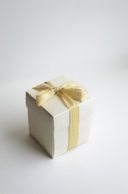İzole altın yay ile beyaz hediye kutusu 