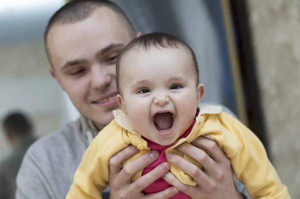 Giovane padre uomo che tiene e abbraccia tra le braccia bambino bambino bambina sorridente ridere — Foto Stock