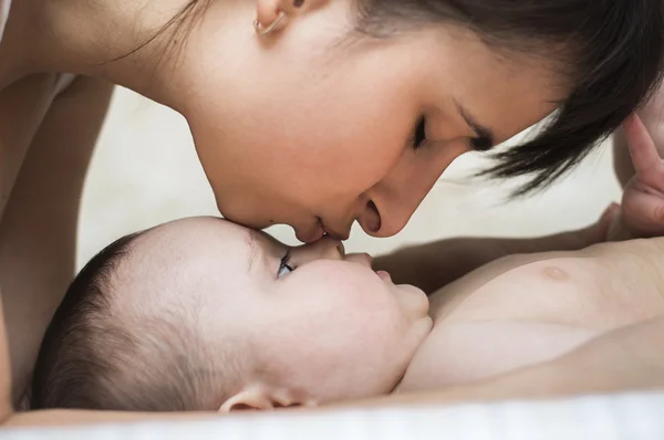 Madre baciare la tenerezza del naso del bambino — Foto Stock
