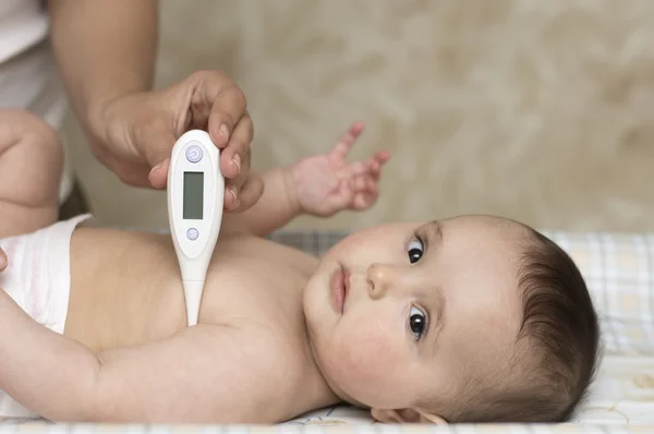 Matka měří teplotu dítěte — Stock fotografie