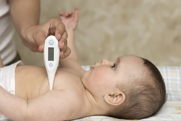 Anne çocuk bebek sıcaklığını ölçer — Stok fotoğraf