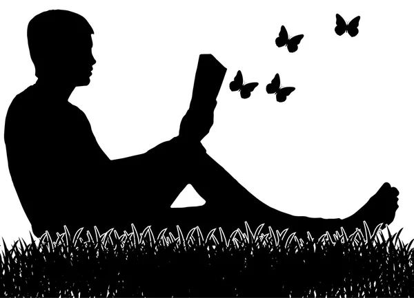 Adam çimenlerin üzerinde oturan ve bir kitap okuma