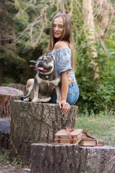 Ein Junges Mädchen Mit Einer Französischen Bulldogge Sitzt Auf Einem — Stockfoto