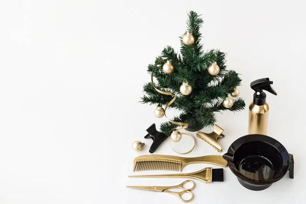 Altın rengi kuaför aletleri ve beyaz arka planda bir Noel ağacı olan afiş. Kuaför salonu aksesuarlarıyla birlikte tatil şablonu.