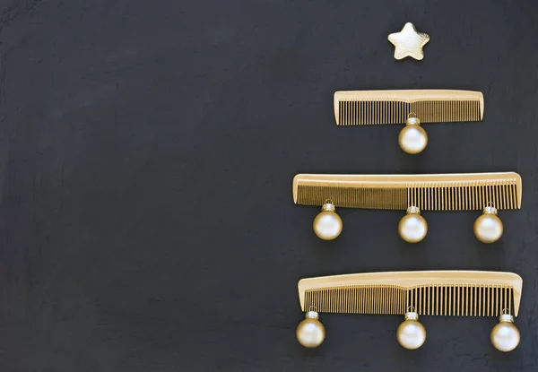 Koyu gri arka planda altın taraklardan yapılmış Noel ağacı. Mesaj atmak için yeri olan bir kuaför salonu için yılbaşı şablonu. Kuaför aksesuarlarıyla tatil afişi.