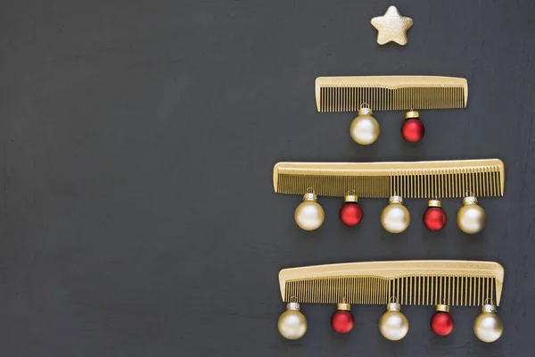 Christmas tree made of gold combs on a dark gray background. New year\'s template for a hair salon with space for text. Holiday banner with Barber accessories.