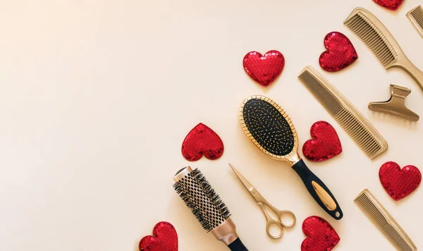 Modelo de dia dos namorados com ferramentas de cabeleireiro e corações. Acessórios de salão de cabeleireiro dourado no canto em um fundo bege claro com espaço para texto. — Fotografia de Stock