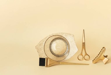 Altın berber aletleriyle şablon. Kuaför salonu aksesuarları, makas, fırça ve sarı arka planda saç boyası. Kopyalama alanı olan pankart.